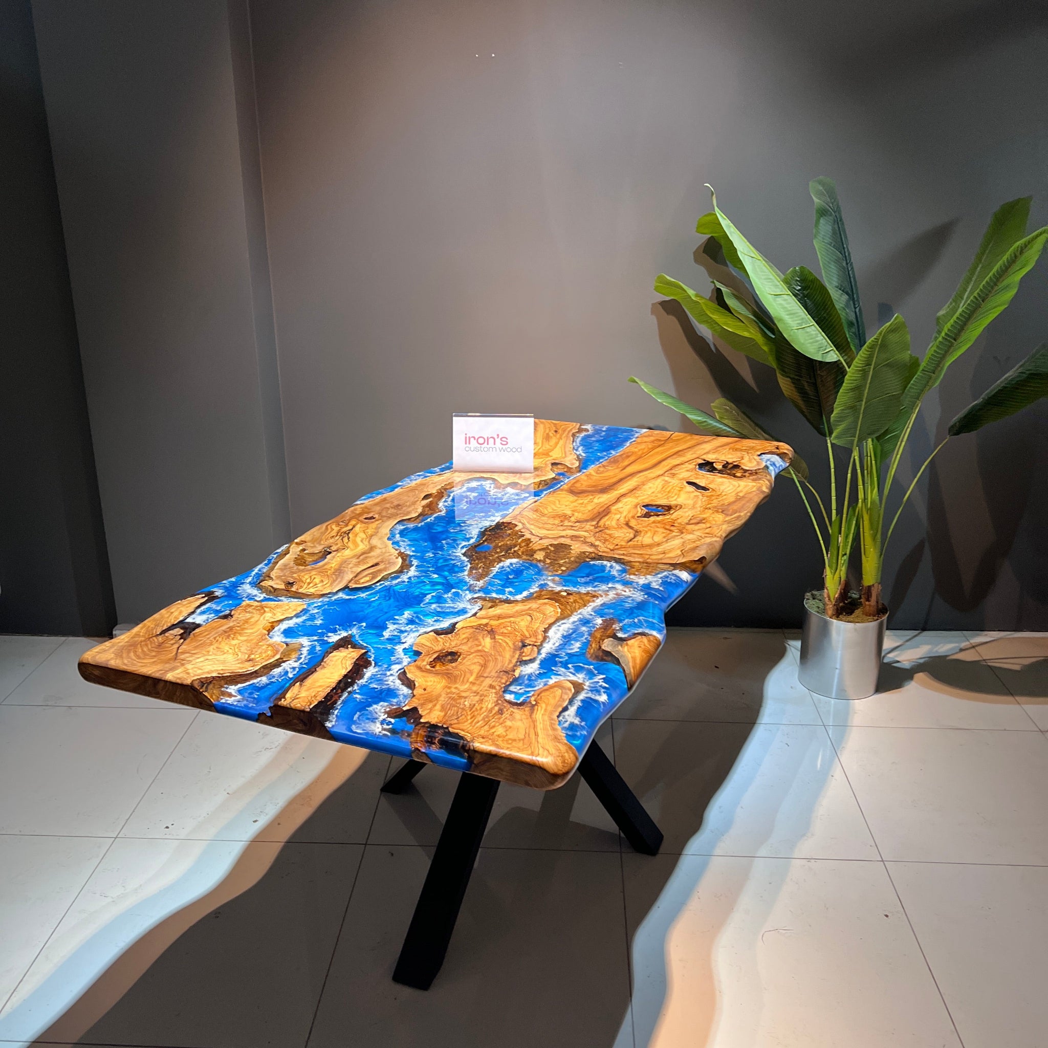 Decorative wooden table with a blue and gold design on a tiled floor.